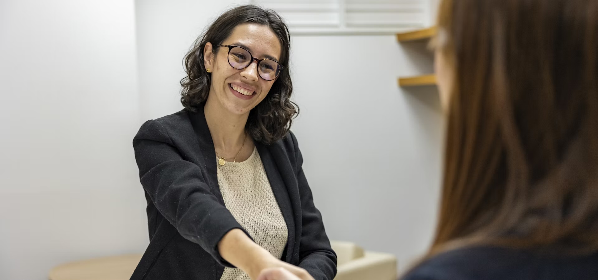 Friendly consultant smiling on the phone at a modern open-plan office desk