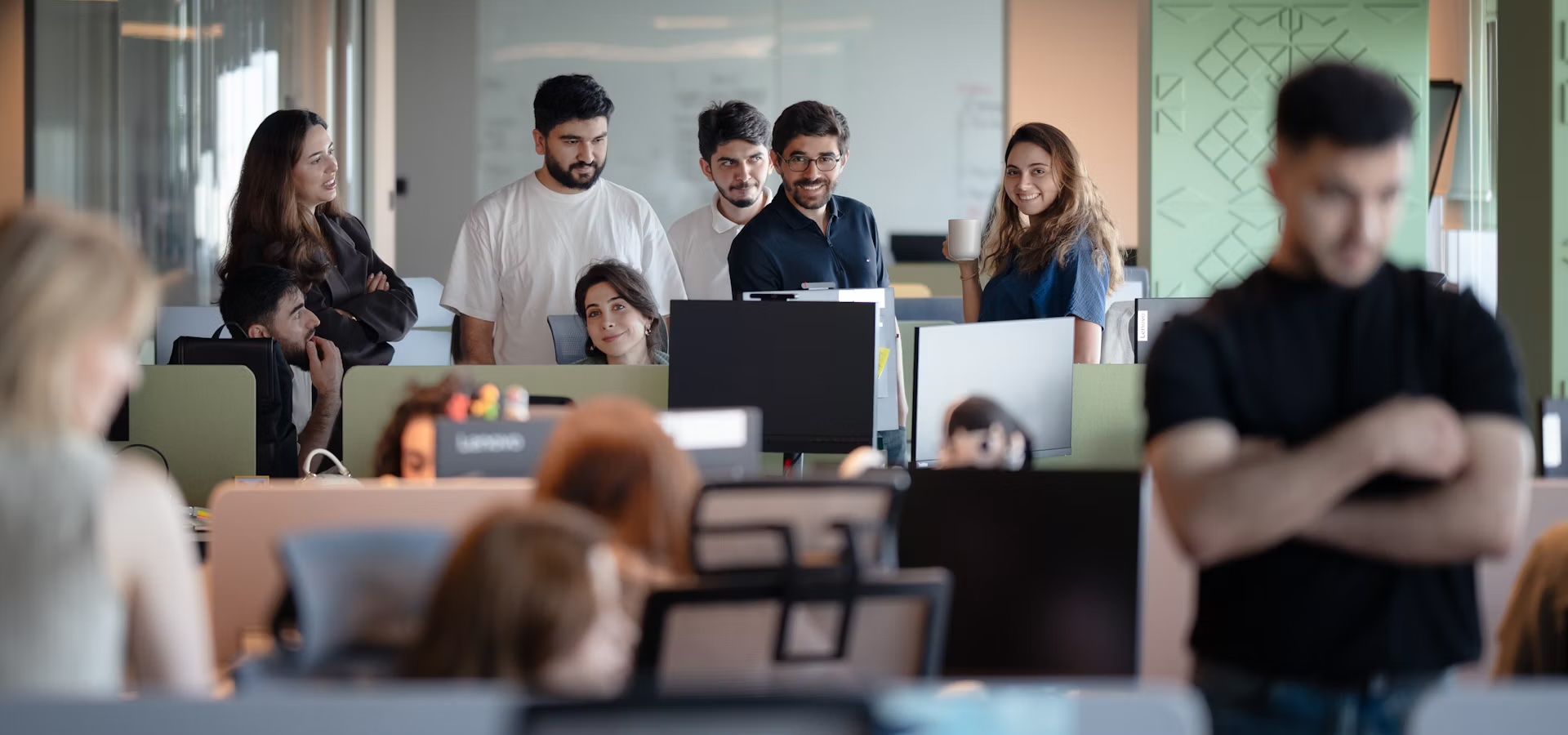 Friendly consultant smiling on the phone at a modern open-plan office desk